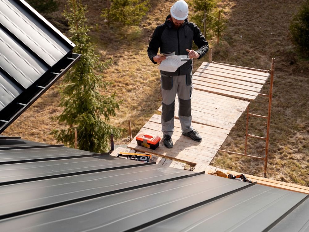 Global Roofing crew member reviewing plans on a metal roof installation