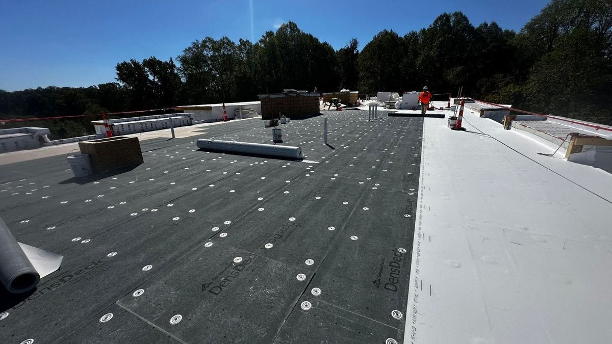 Commercial flat roof with new cover board and TPO membrane being installed